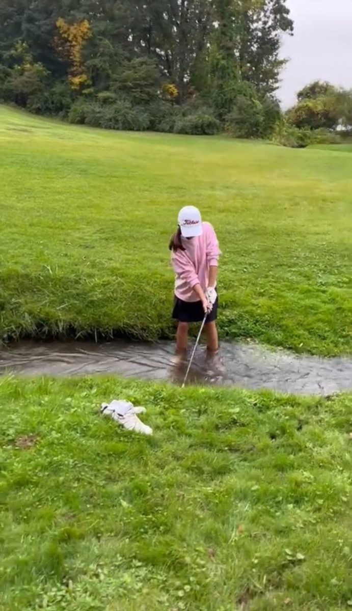 Belle Felt hitting out of a stream at hole  9 woods at Mystic Creek Golf Course (Photo by Stephen Lawatsch).
