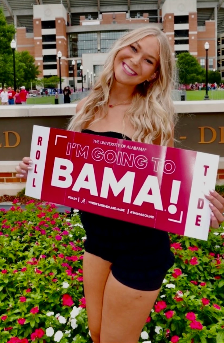 Senior Olivia Diaz holds a banner while on an official tour (Photo courtesy of Olivia Diaz). 
