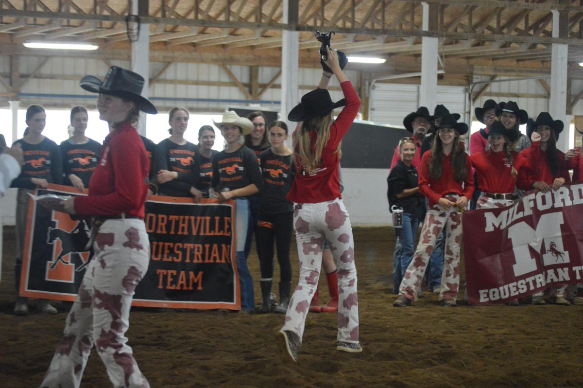 Avery Jarecki and Kara Peltier carry a trophy back to their team after winning first place.
