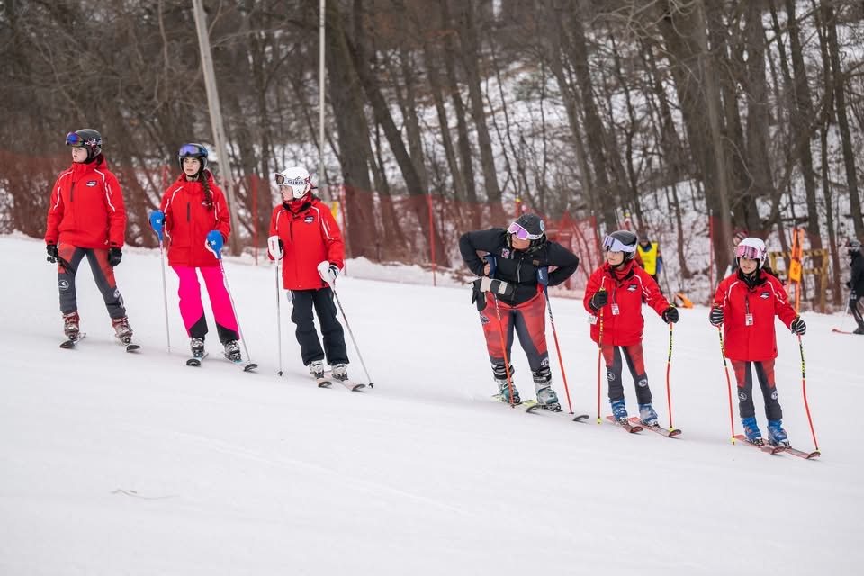 The girl’s ski team lining up for inspection before a race 
