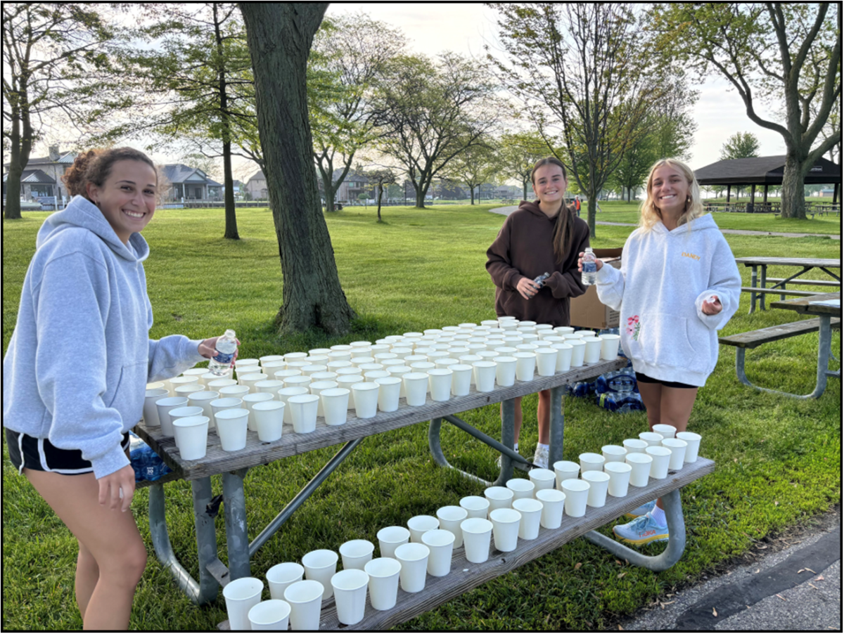 Milford students Payton Wertz, Ella Hendry and Macy Jenkins volunteering at the YMCA 5k race passing out water cups. 