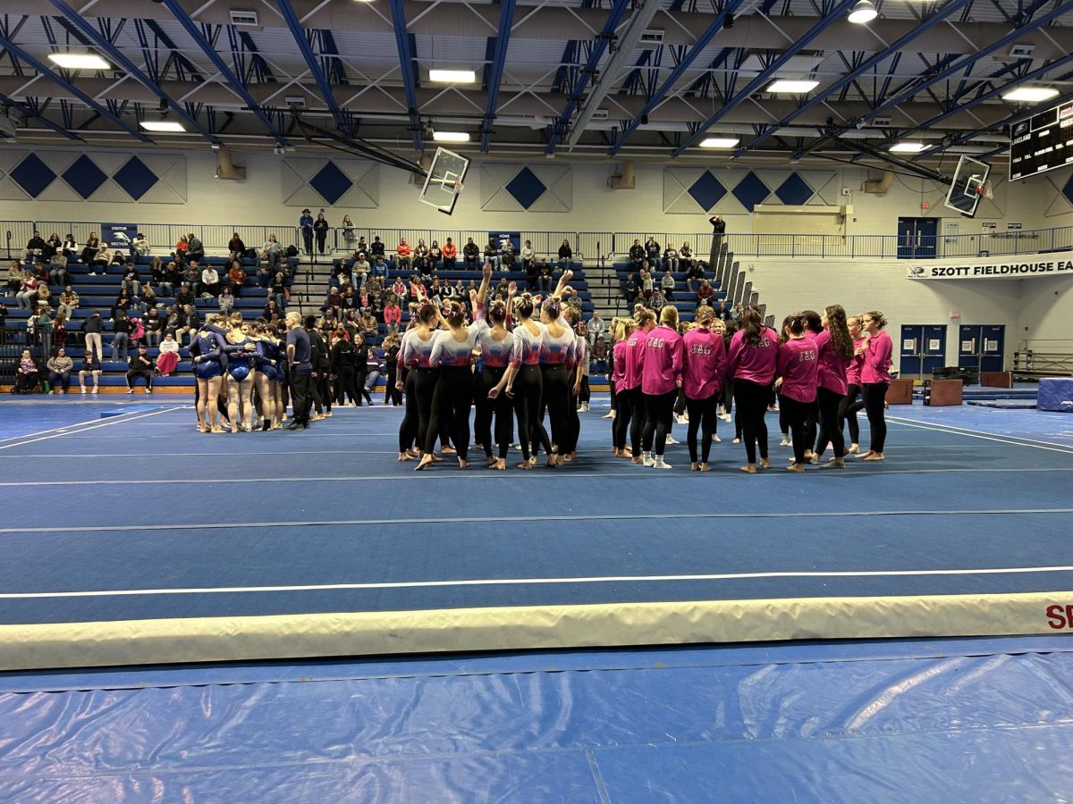 The team doing a group huddle before going to compete. 
